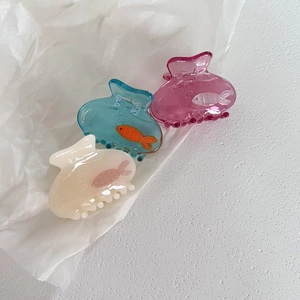 Close-up of translucent fish-shaped hair clips with cute ocean patterns and bubble textures