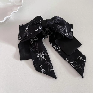 Elegant black bow hair claw clip with white bamboo leaf patterns and chiffon texture