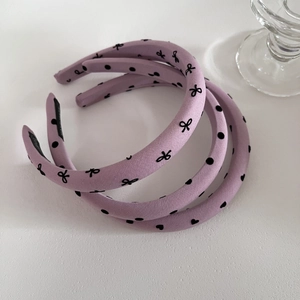 Détail de serre-têtes rembourrés lavande avec motifs pois et cœurs et étiquettes faites main