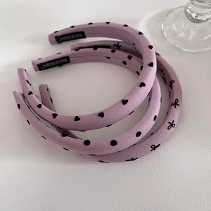 Détail de serre-têtes faits main lilas avec motifs à pois et cœurs élégants
