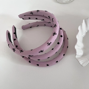 Détails de cinq serre-têtes en tissu violet avec des pois noirs et des nœuds doux