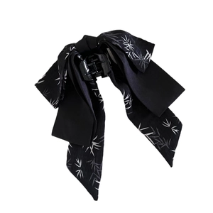 Elegant black silk bow hair claw clip with white bamboo leaf patterns on white background