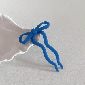 Épingle à cheveux en acétate bleu brillant avec nœud papillon sur support blanc