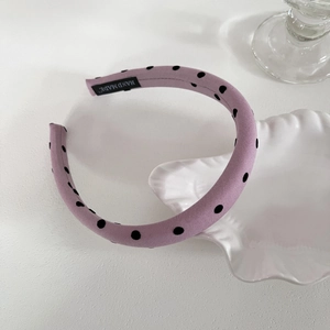 Serre-tête violet clair à pois noirs élégant sur un plateau en porcelaine blanche