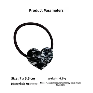 Detail of marble pattern acetate heart hair tie with France Handmade gold lettering