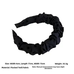 Detail of grey ruffled headband with black flocked dots made of twill fabric