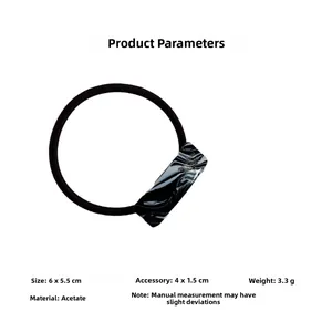 Detail of high-elasticity black hair tie featuring a marbled acetate rectangular charm