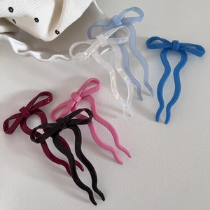 Détail d'épingles à cheveux en acétate avec nœud en six couleurs sur fond blanc