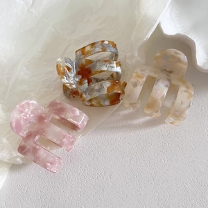 Trois pinces à cheveux en acétate aux motifs marbre rose, ambre et blanc crème