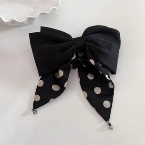 Elegant large black hair claw clip with white polka dot bow and long ribbons on white