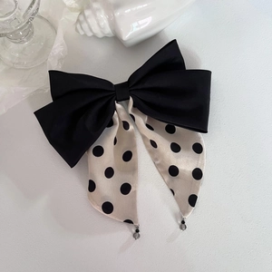 Detail of French polka dot bow hair clip with satin ribbons and beaded charms