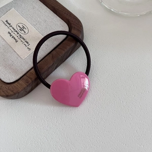 Pink heart hair tie with golden France Handmade stamp on a white textured background