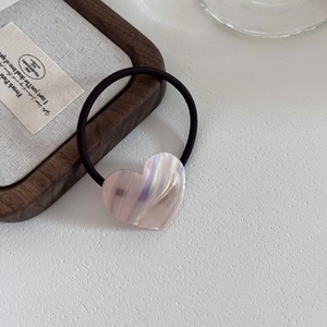 Macro shot of pink acetate heart hair tie with France Handmade engraving and elastic band