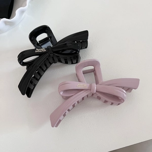 Elegant large bow hair claws in black and dusty pink with glossy finish and gold lettering