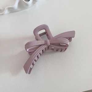 Elegant lavender bow hair claw clip made of glossy resin with gold lettering detail