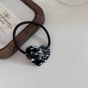 Detailed close-up of marble pattern heart charm with golden France handmade engraving