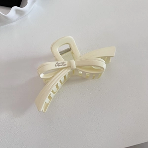 Macro detail of cream bow hair claw clip with silver Barrette La France engraving