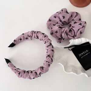 Ensemble serre-tête et chouchou violet avec motif nœud sur fond blanc texturé chic