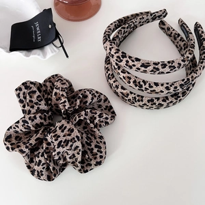 Retro leopard print hair accessory set with scrunchie and handmade headbands on white desk