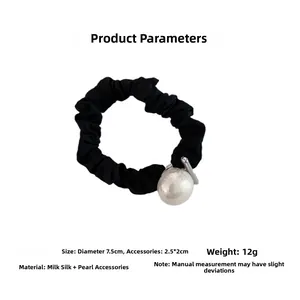 Detail of black milk silk scrunchie with a large pearl bead and size specifications