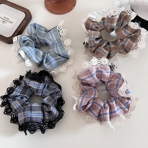 Detailed close-up of four plaid scrunchies with delicate lace edges in vintage style