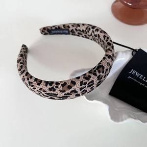 Detail shot of the thick leopard print headband showing handmade inner label and fabric texture