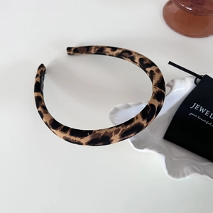 Vintage leopard print headband with handmade lettering on a minimalist background