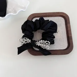 Elegant black satin scrunchie with a silver bead bow decoration for women hair styling