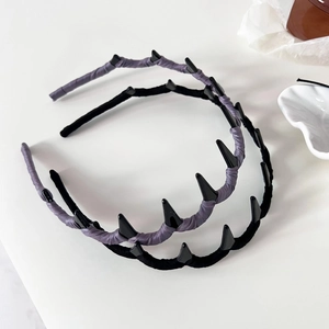 Detailed view of wavy fabric headbands in purple and black with unique spiked texture