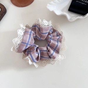 Detailed view of pink and blue checkered fabric hair scrunchie with white floral lace trim