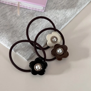 Drei Perlen-Blumen-Haargummis in Schwarz, Kaffee und Beige mit goldenem Metallrand im Detail
