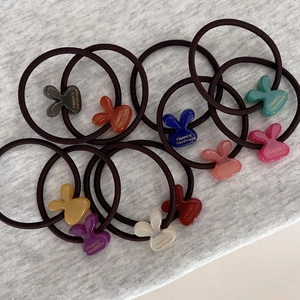 Cute bunny head elastic hair ties in candy colors on grey knit background
