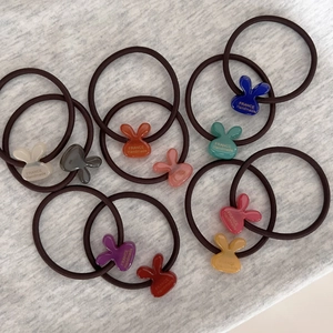 Detailed set of colorful bunny hair ties with France Handmade logo on soft knit background