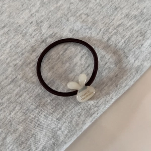 Detailed shot of elastic hair tie with translucent rabbit ears and handmade lettering