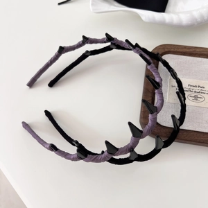 Solid color fabric wrapped wavy headband with resin spikes for a voluminous punk hairstyle