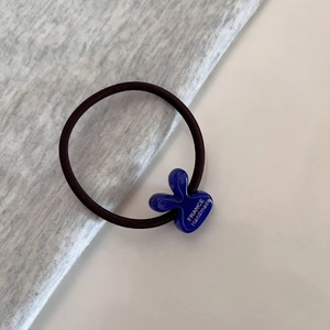 Close-up of a blue rabbit ear hair tie with France Handmade text on elastic rope