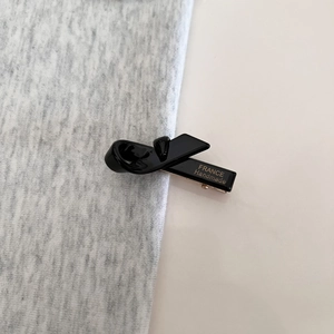 Detail of black glossy bow hair clip with gold France Handmade lettering on side
