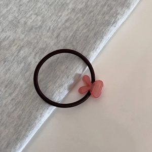 Detail of pink acrylic bunny charm on high elastic hair tie with handmade engraving