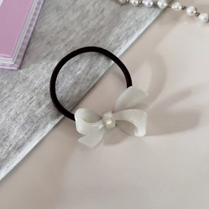 Detail of high-elasticity black hair tie with white marbled acetate bow decoration