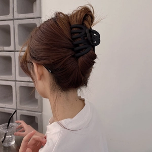Matte black oversized hair claw clip for thick hair shown on a female hairstyle