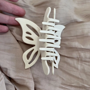 Elegant cream butterfly claw clip for hair styling with glossy acetate finish and metal spring