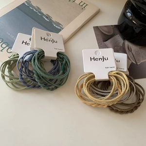 Macro detail of elastic woven hair ties in Morandi tones with elegant card packaging
