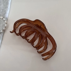 Détail d'une pince à cheveux ambrée translucide avec design à dents lisses pour cheveux