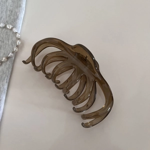 Détail d'une pince à cheveux en résine marron ambre translucide au fini brillant