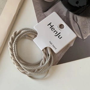Detail of beige spiral braided hair ties with high elasticity on original packaging