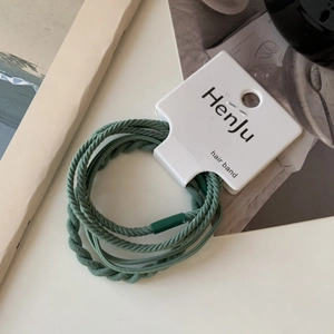 Detail of high-elasticity grass green braided hair band on its original display card