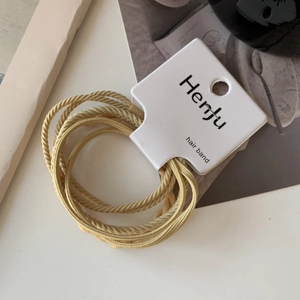 Macro view of light yellow high-elasticity hair band with ribbed woven texture and tag