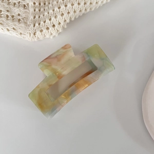Detail of large rectangular acetate hair claw clip with colorful marble pattern