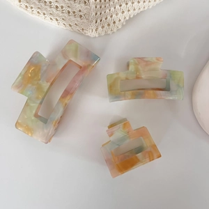 Three-piece acetate claw clip set with marble texture in pink and orange tones