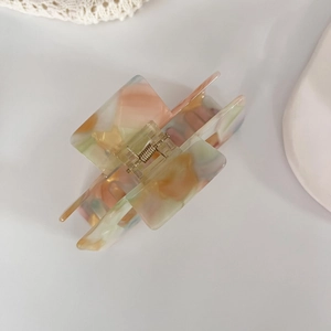 Detail of colorful marble acetate square hair claw clip with strong golden metal spring